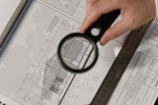 Un expert immobilier examine les documents techniques d'une maison avant son évaluation